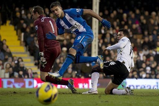 Wigan's Franco Di Santo (C) fights for the ball with Fulham's Mark Schwarzer (L) & Kieran Richardson, January 12, 2013